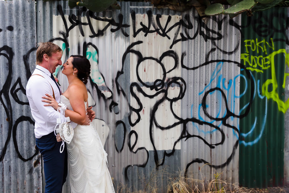 bride and groom embracing in the alleyway next to post office hotel at their wedding