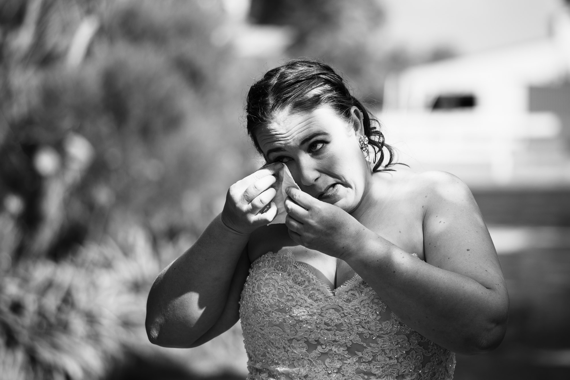 black and white image of bride crying as she walks down the aisle