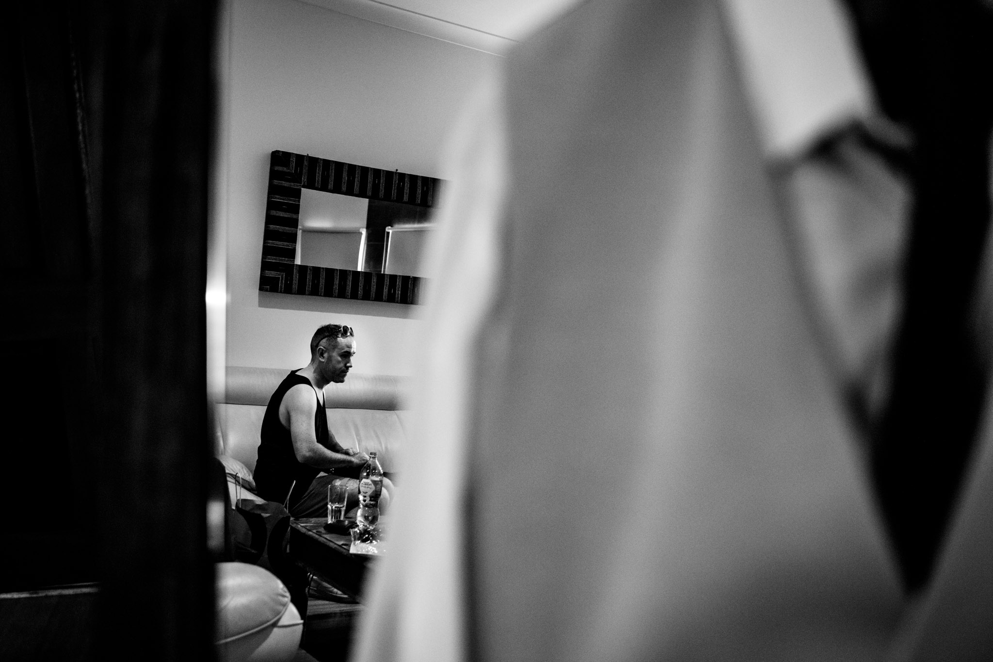 black and white photo of groom getting ready